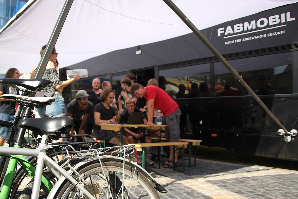 Eine Gruppe von Menschen vor dem Fabmobil auf dem Zittauer Marktplatz.
