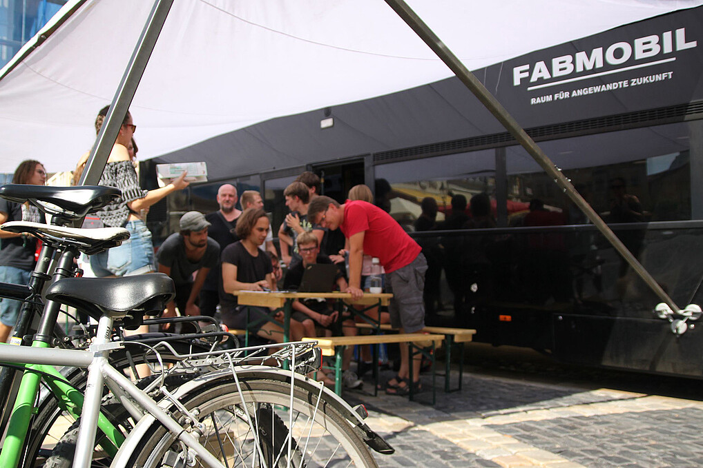 A group of people in front of the Fabmobile on Zittau's market square.