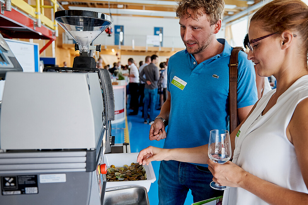 A man and a woman stand in front of a technical system