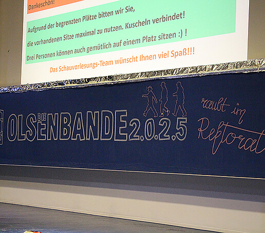 Olsenbande is written on a long blackboard.