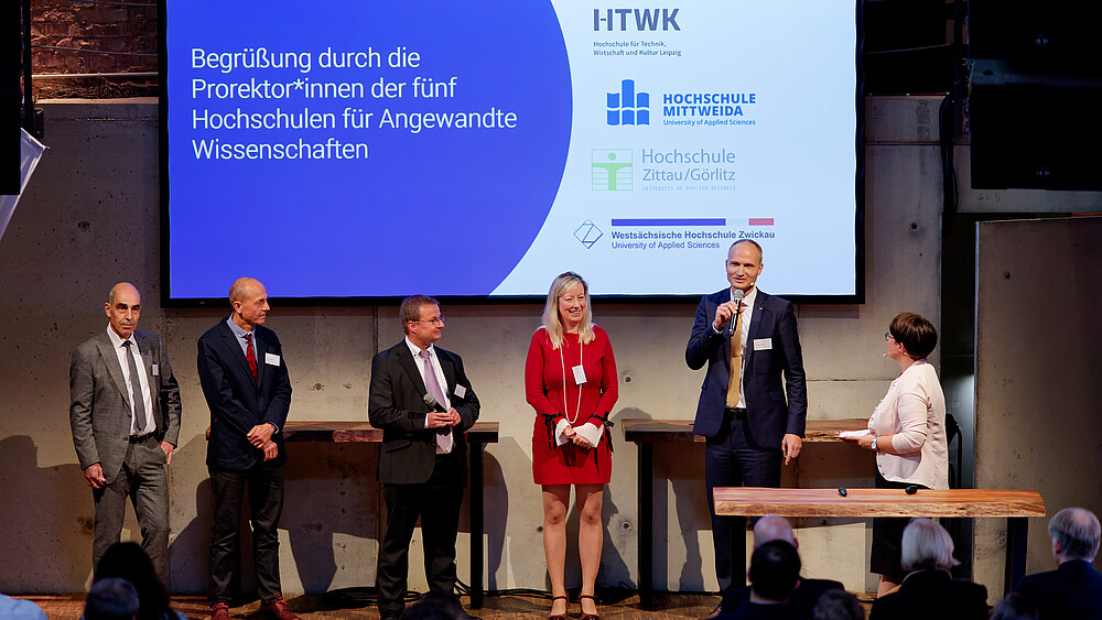 Four guests on stage, including the Vice Rector