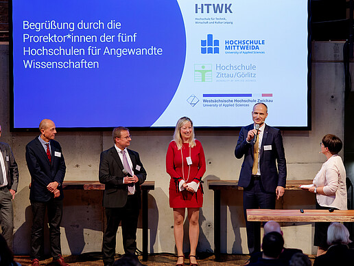 Four guests on stage, including the Vice Rector