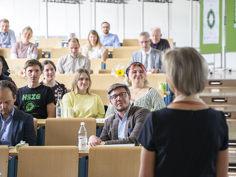Die Prorektorin steht zu vollbesetzten Sitzreihen im Hörsaal zugewandt.