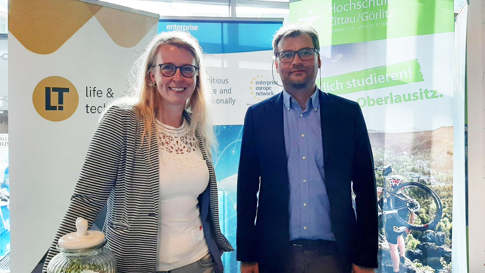 Two employees of the transfer projects Lausitz - Life & Technology and Enterprise Europe Network at an exhibition stand.