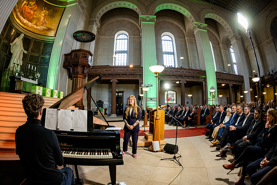 Victoria Hohlfeld stands next to Samuel Wagner at the grand piano and sings for the audience at St. John's Church.