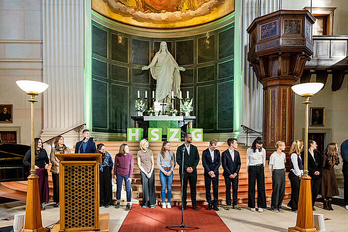 A large group of Germany Scholarship recipients is standing in the chancel of St. John's Church in Zittau.