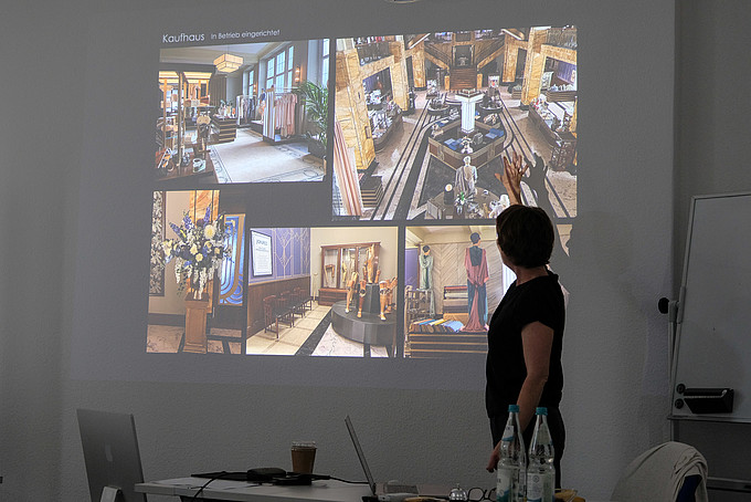 In the darkened seminar room, the lecturer looks at a beamer projection on which various movie backdrops can be seen.