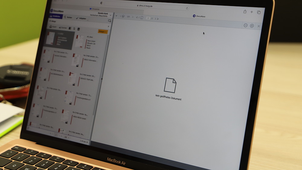 The DMS interface can be seen on the screen of an opened Macbook.