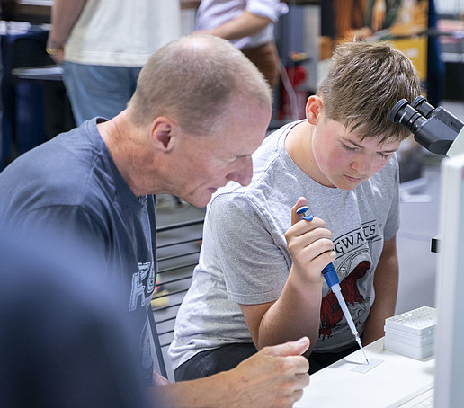 A boy pipettes at a test stand.