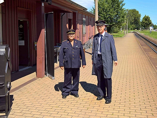 Lecturer Hans-Günter Krüger and laboratory engineer Volker Brade in front of the rush of visitors in Deutsche Reichsbahn uniforms in front of Zittau Süd station