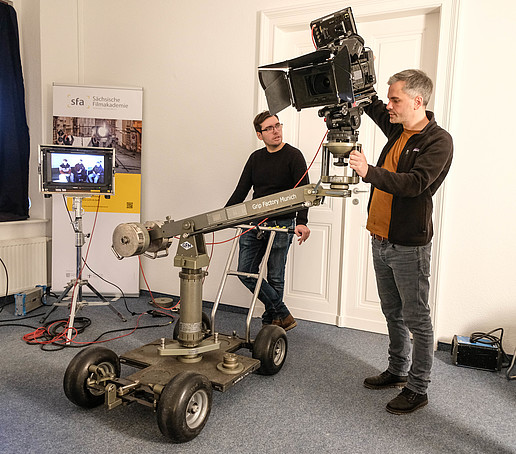 Kursteilnehmer üben im Seminar Dollytechnik im SFA Teamraum mit Filmtechnik.