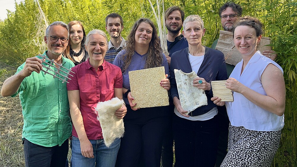 LauTra-Projektteam am Nutzhanf-Versuchsfeld der HSZG mit Naturfasern und daraus gefertigten Beispielprodukten