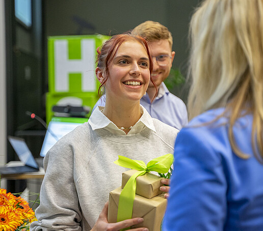 A prizewinner holds a gift in her hands.