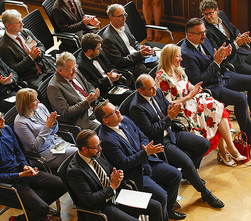 In the Bürgersaal, the audience sits on full rows of chairs and applauds.
