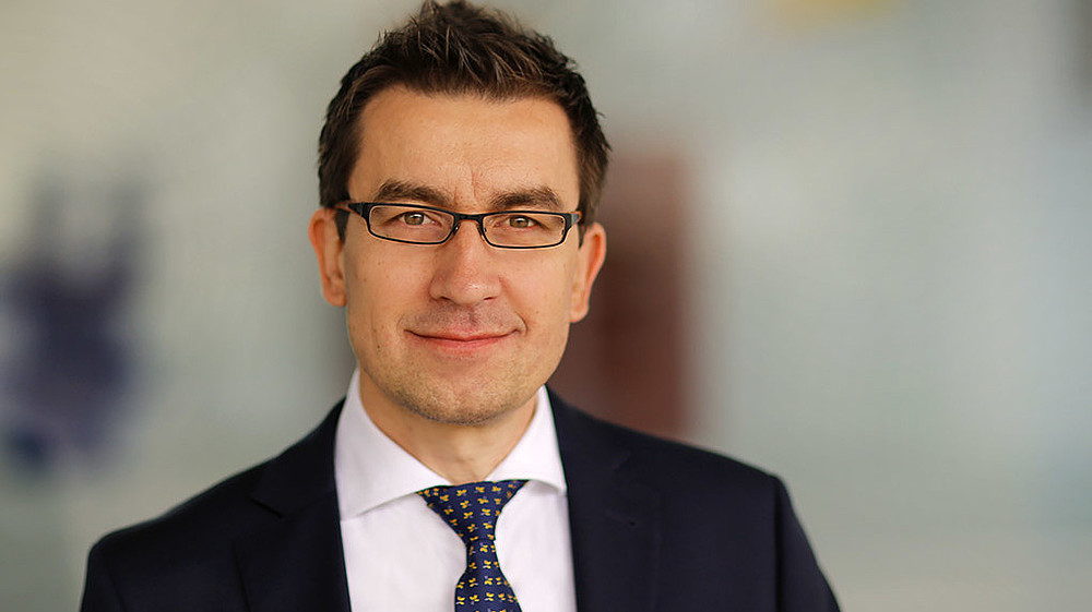 Professor Dzienis smiles into the camera.