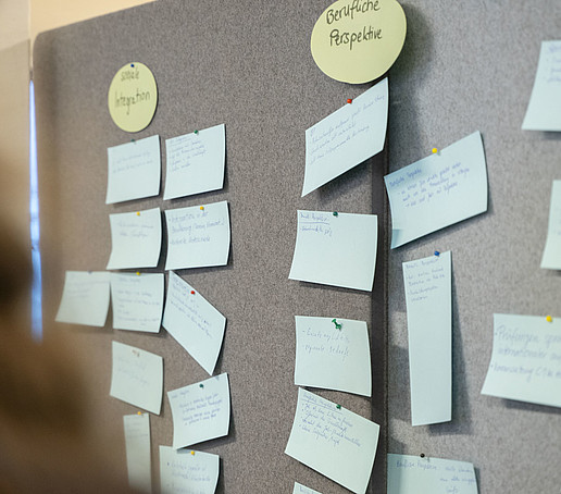 A pinboard is pinned full of written notes.