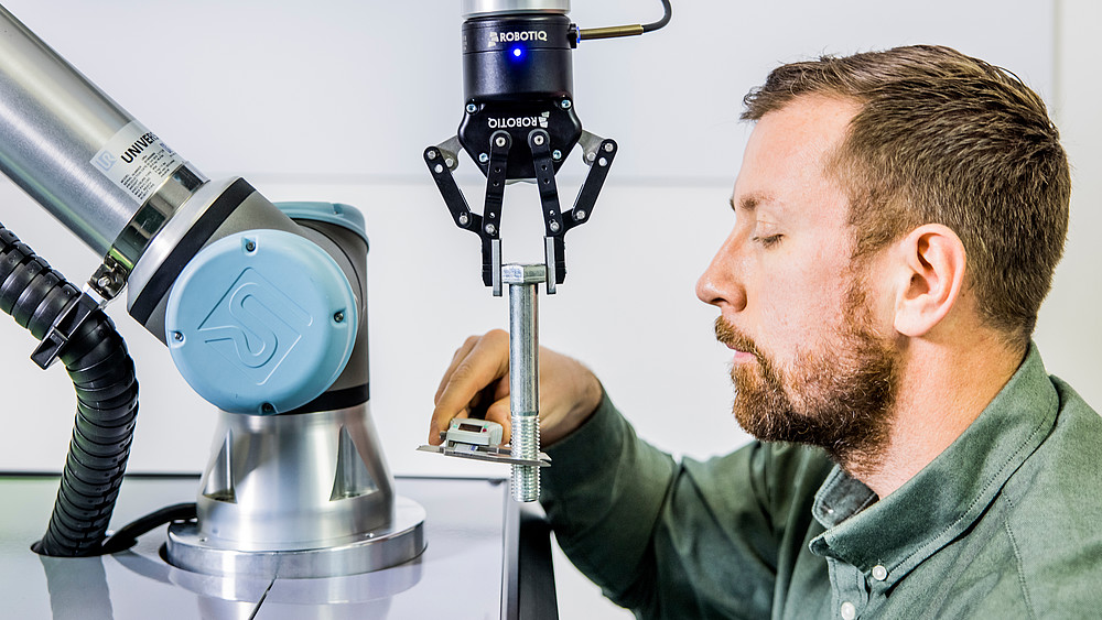 Christian Vogel, Forschungsmitarbeiter am Institut für Prozesstechnik, Prozessautomatisierung und Messtechnik bei einer Präsentation eines kollaborativen Roboters.