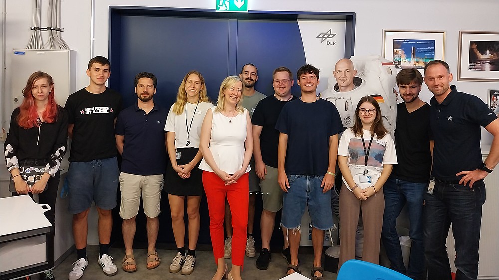 Gruppe von Menschen lächeln im DLR School Lab Berlin in die Kamera.