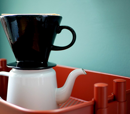 Foto kleine weiße Kaffeekanne und schwarzer Kaffeefilter