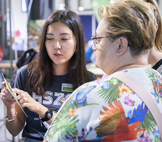 An HSZG employee in conversation with a visitor.