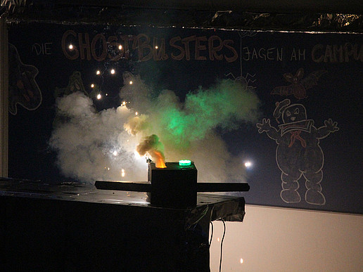 Burning vessel in front of blackboard. A ghost from Ghostbusters is drawn on the blackboard