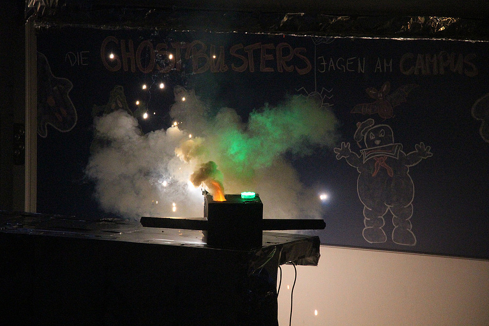 Burning vessel in front of blackboard. A ghost from Ghostbusters is drawn on the blackboard