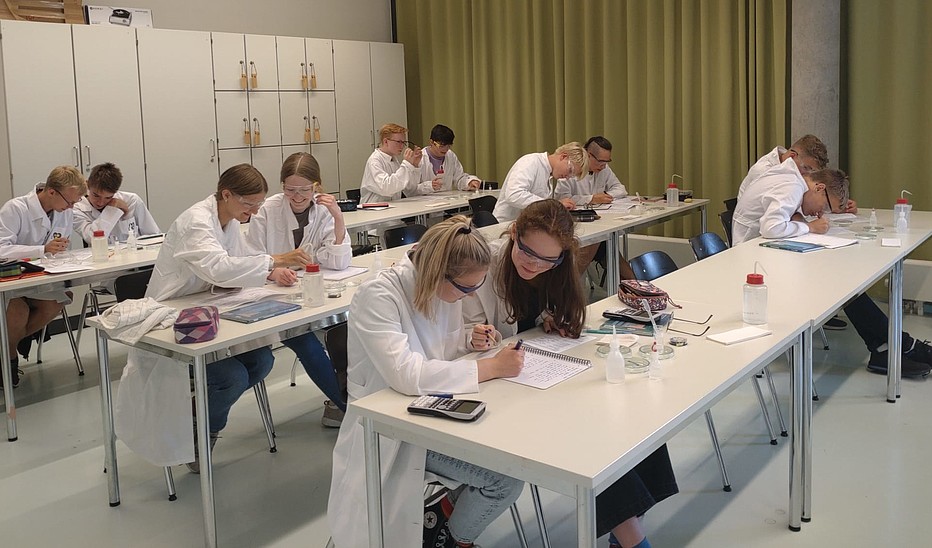 Quelle: HSZG Schülerinnen und Schüler sitzen experimentierend im Labor
