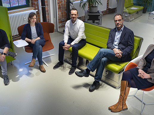 The Life and Technology team sits in a semicircle in the rooms of the co-creation lab at Celsiuz and smiles at the camera.
