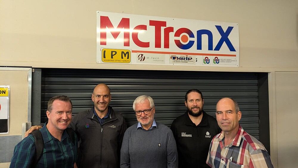 Prof. Worlitz (center) with Prof. Kenny Uren (left) and other NWU colleagues in front of the NWU mechatronics lab