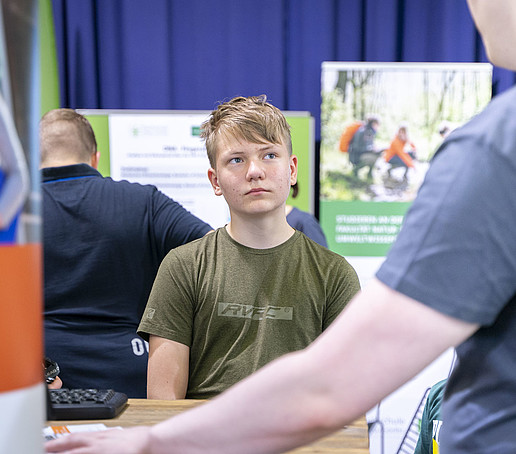 Ein Schüler informiert sich am Stand.