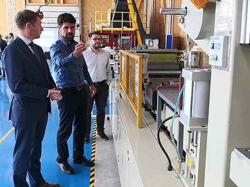 Minister President Michael Kretschmer, Prof. Scholz and Prof. Weber stand in front of a machine