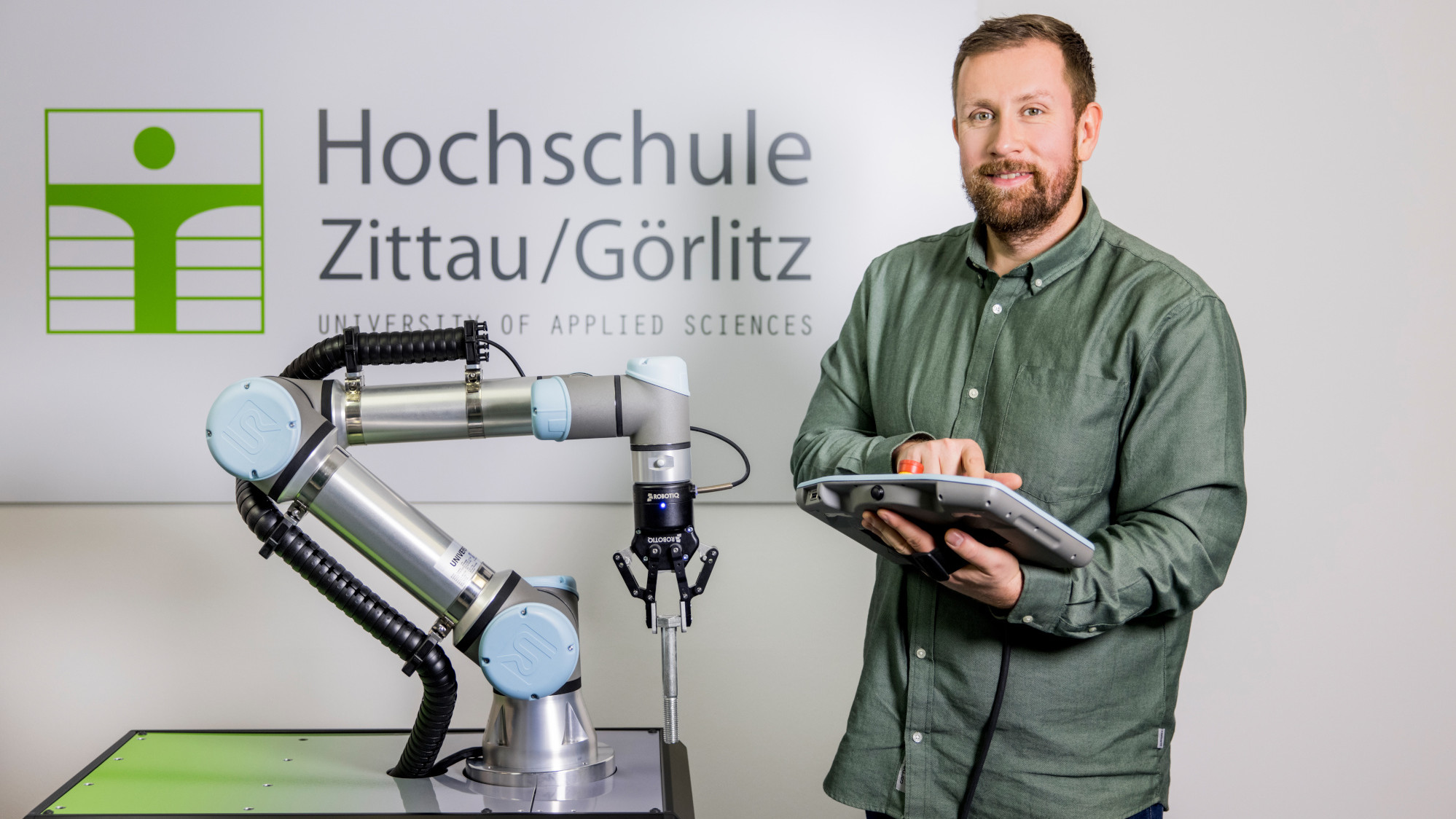 Foto: Carla Schmidt Ein Roboterarm wird von einem Mitarbeiter bedient.