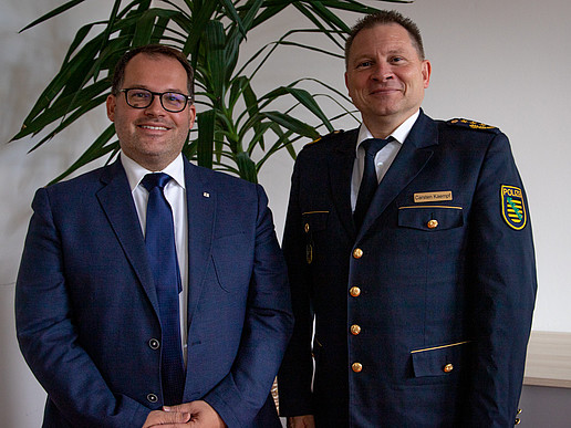 The rector and police chief Carsten Kaempf smile into the camera.