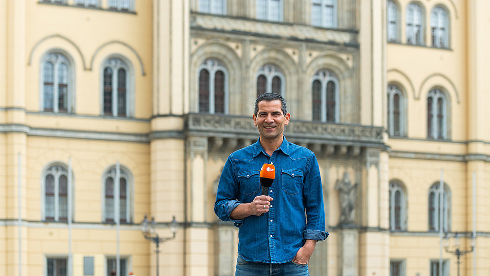 Moderator Mitri Sirin steht vor dem Zittauer Rathaus