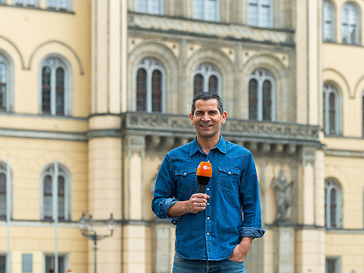 Presenter Mitri Sirin stands in front of Zittau town hall