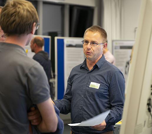 An employee talks to a guest in the poster exhibition.