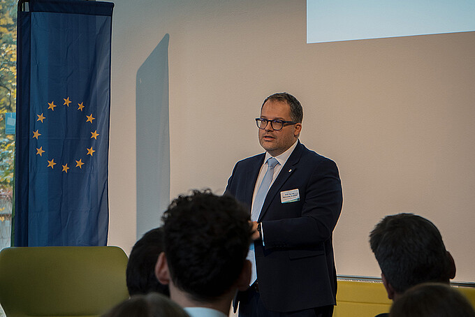 The principal speaks to an audience in the auditorium.