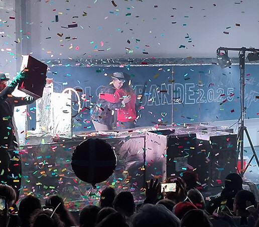 Two performers embrace in a shower of confetti.