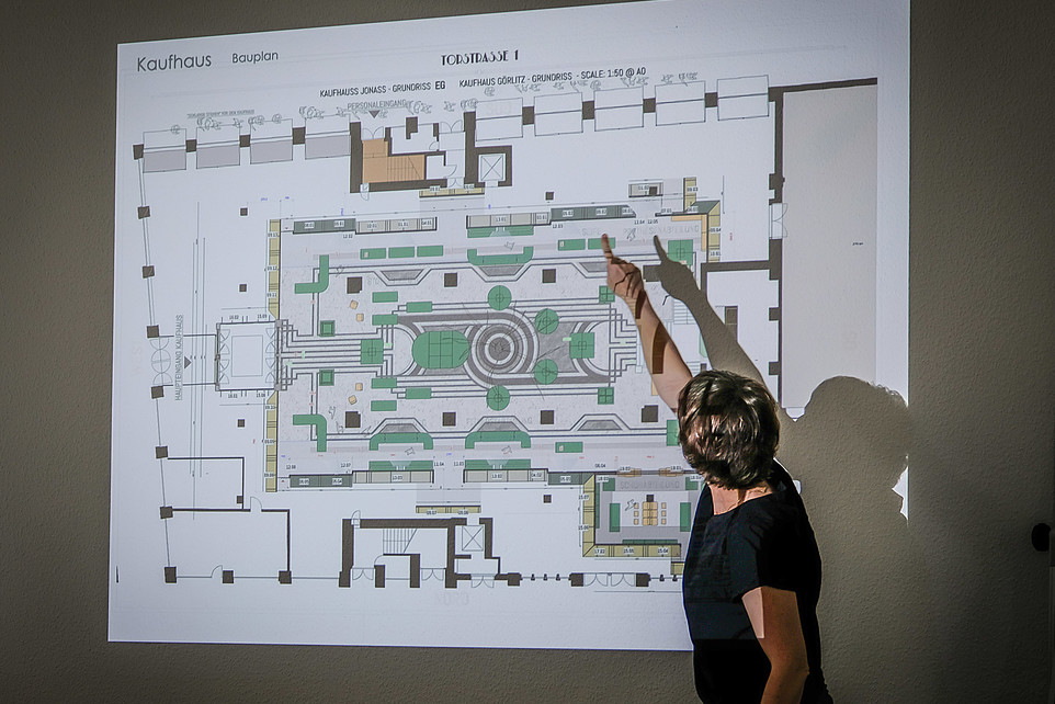 The lecturer explains the teaching content using a beamer projection. You can see the floor plan of a movie set.