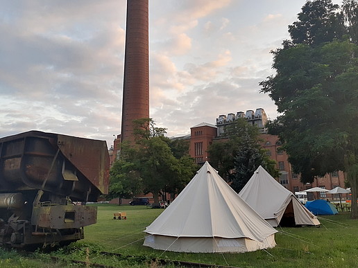 Camp mit Zelten im Freien vor den Fabrikgebäuden in Knappenrode