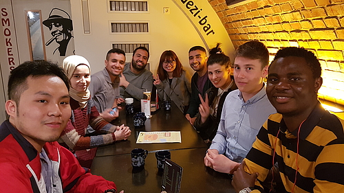 Gruppe von Studenten verschiedener Nationalitäten in einer Bar