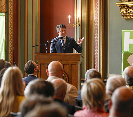 Mayor Zenker stands at the lectern and gives a welcoming address.