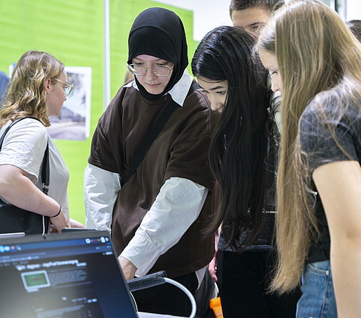 Visitors gather information from an employee at a table.