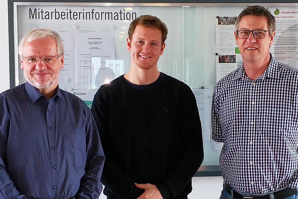 Three men in a row, positioned for the photo.