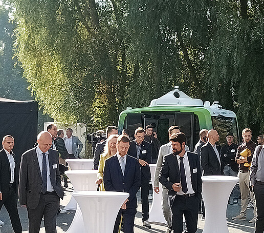 Die Gäste und der Ministerpräsident gehen zu den Stehtischen im Außengelände.