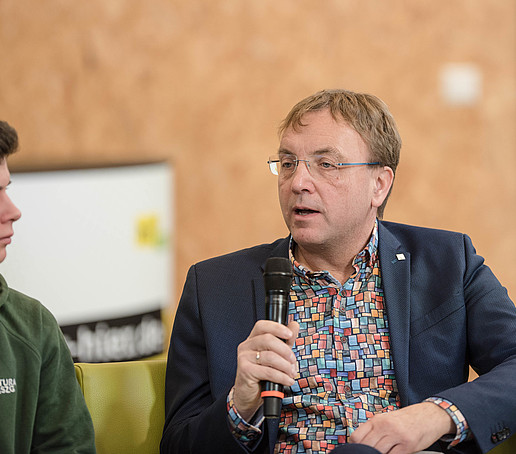 Prof. Kroschel with microphone on the talk sofa