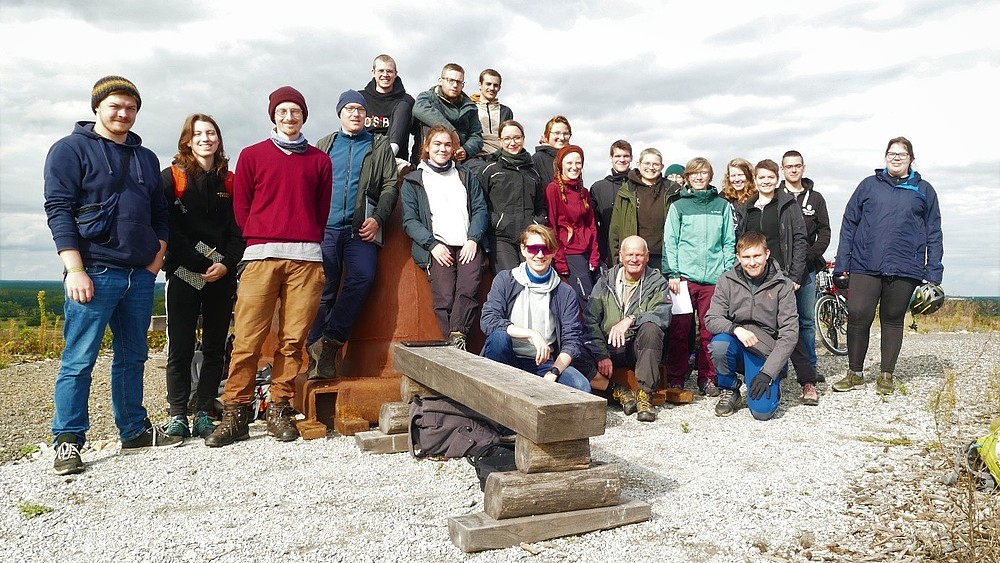 A group of students and a professor in a stony landscape.
