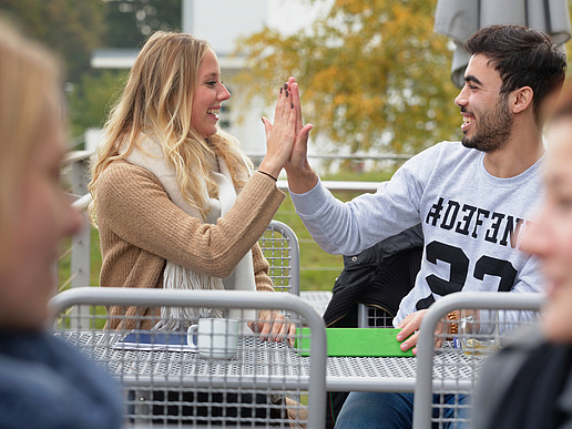 Studentin und Student klatschen sich ab.