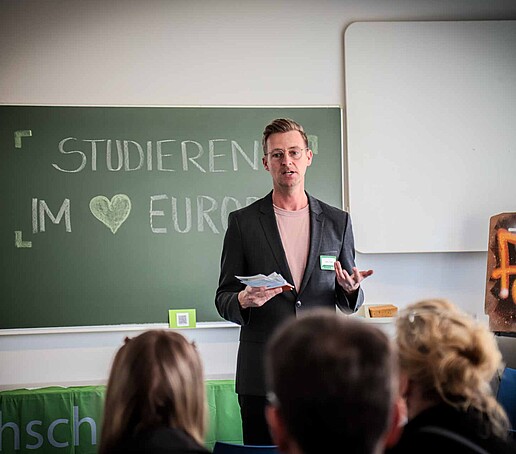 Mr. Donath stands in front of a group of prospective students sitting in front of him and provides information about the Management orientation course.