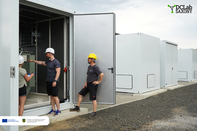 Employees wearing helmets enter a container